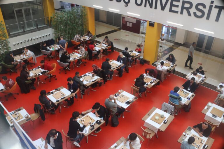 Players at their boards in the red floored playing hall of Doğuş University