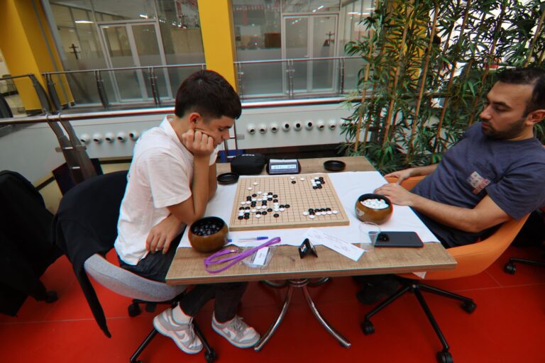 Two players at a go board during round 5