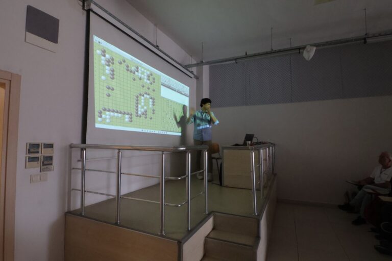 In-seong Hwang lecturing in front of a projected go board